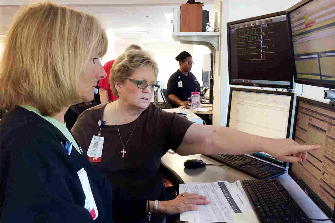 Nurses Patricia Wegener (left) and Susan Davis at Mercy Hospital can monitor the condition of a patient who is miles away via the hospital's technology. But some health insurers and analysts remain skeptical that telemedicine saves money.
