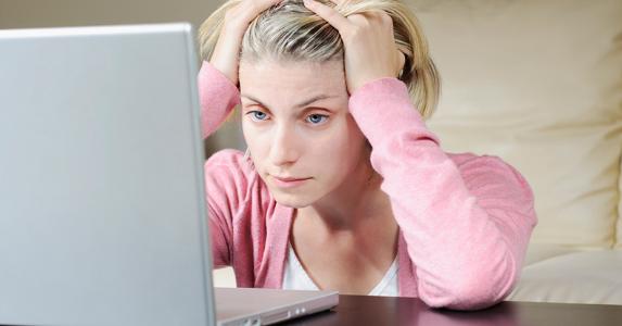Woman holding her head in her hands &copy; iStock